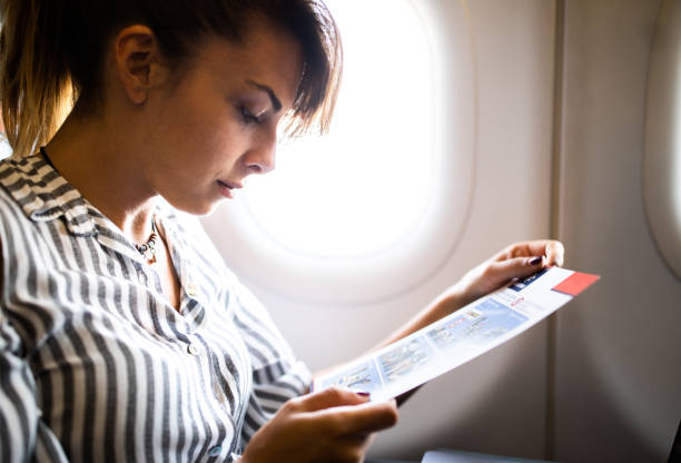 istock Young woman reading while traveling by plane. 1341801533