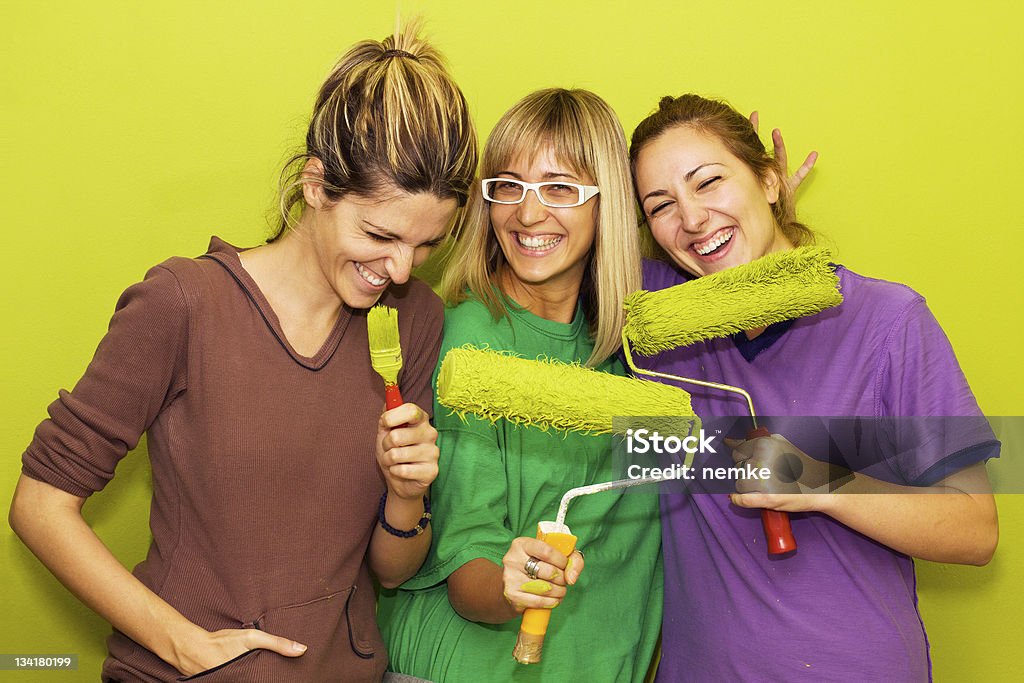 Young friends Young friends painting a room, smiling. DIY Stock Photo