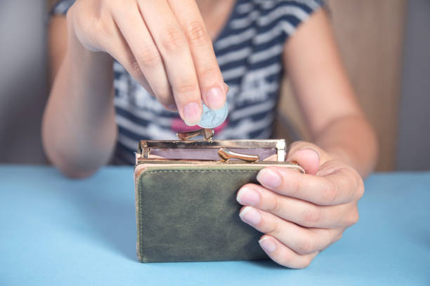 istock woman holding wallet with coins 1341807567