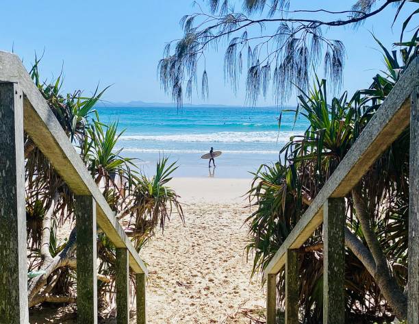 Surfer on Sand after Surfing Ocean Waves stock photo