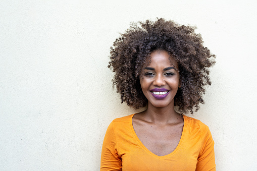 Portrait of a natural and genuine afro american woman, new canons of beauty and body positive, smile of a african woman with curly hair