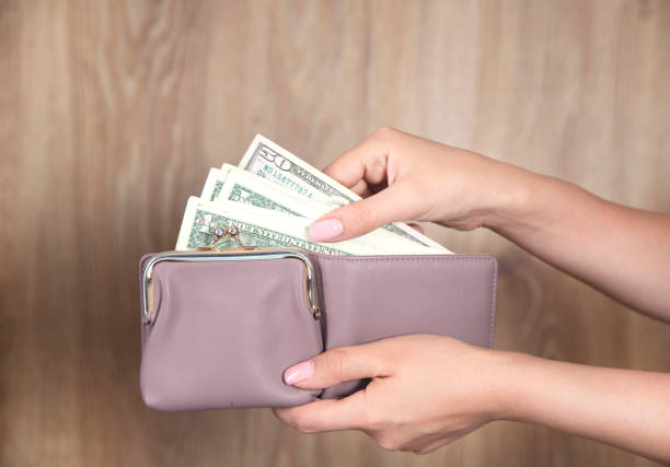 istock woman holding wallet with money 1341809078