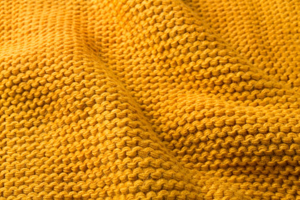 istock yellow knitted fabric with folds, close-up, selective focus 1341809203
