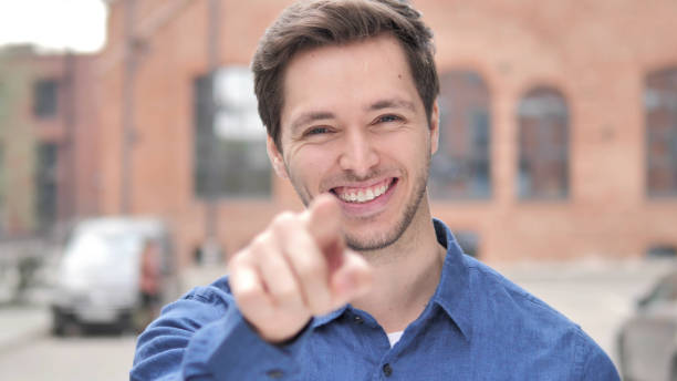 istock Outdoor Standing Young Man Pointing with Finger toward Camera 1341811525
