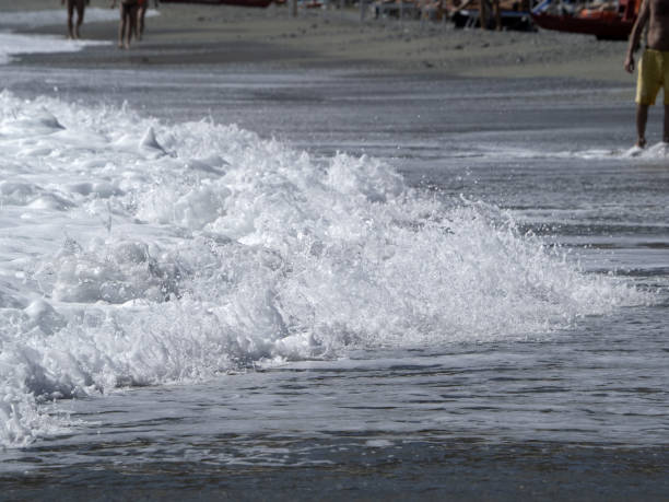 istock Sea wave foam on the sand beach shore 1341811797