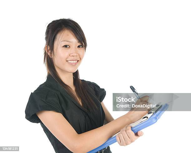 Businesswoman Writing On Clipboard Stock Photo - Download Image Now - 20-24 Years, 20-29 Years, 25-29 Years