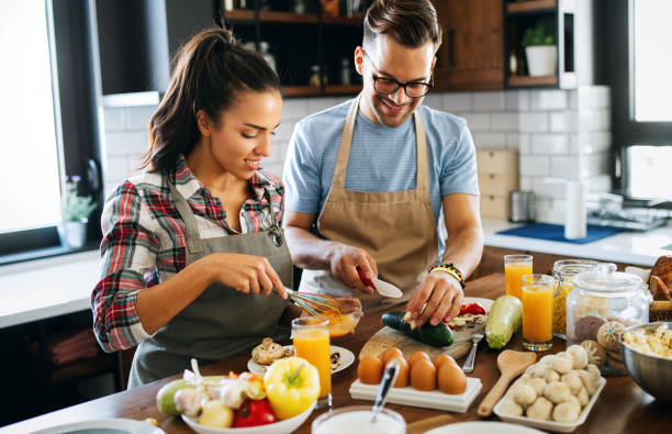istock Beautiful couple is smiling while cooking together in the kitchen 1341814998
