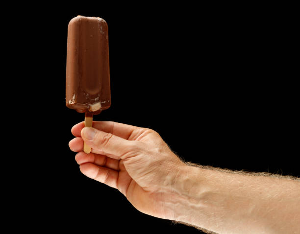 istock Chocolate ice cream on a stick in hand 1341815030