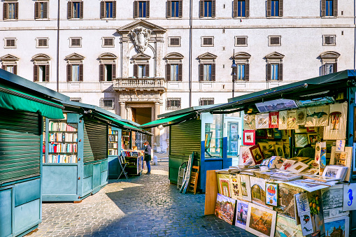 Rome, Italy, November 13 -- A market of antique prints and books (Borghese Square), in the historic and baroque center of Rome, located between the Tiber River and the elegant Via del Corso. In the background the sumptuous facade of Palazzo Borghese, built between 1590 and 1623 as the seat of one of the most important and influential families in Rome. The immense artistic treasures present in this building are now visible in the museum of the Borghese Gallery. In 1980 the historic center of Rome was declared a World Heritage Site by Unesco. Image in high definition format.