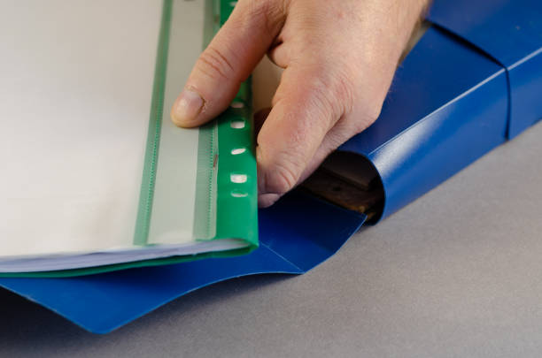istock A mature male hand is holding a green file folder. Blue document 1341820779