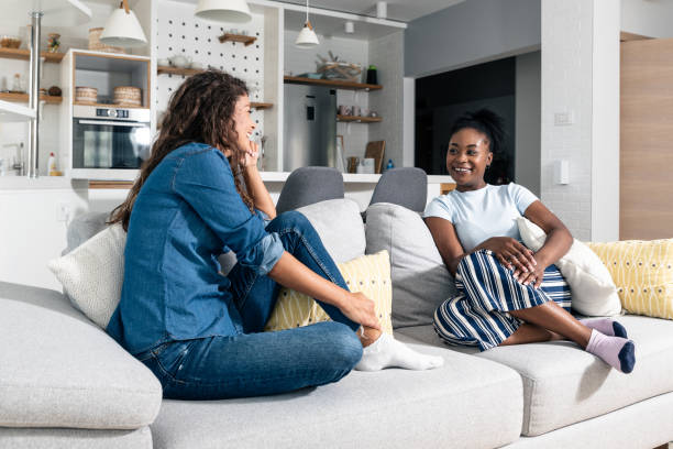Young homeowner woman sitting on a sofa with a young female student who wants to rent an apartment to live in while she is studying in college and discussing price terms and obligations Young homeowner woman sitting on a sofa with a young female student who wants to rent an apartment to live in while she is studying in college and discussing price terms and obligations roommate stock pictures, royalty-free photos & images
