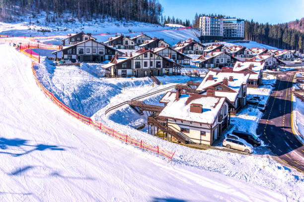 Aerial view of ski slopes and tourist cottages in the winter ski resort Bukovel, Ukraine Palianytsa village, Ivanofrankivsk region, Ukraine - January 14, 2021: Skiers and snowboarders resting at the Bukovel ski resort in the Carpathian mountains, Ukraine. Beautiful modern hotels and ski slopes. Active rest and holidays bukovel ski resort ukraine stock pictures, royalty-free photos & images