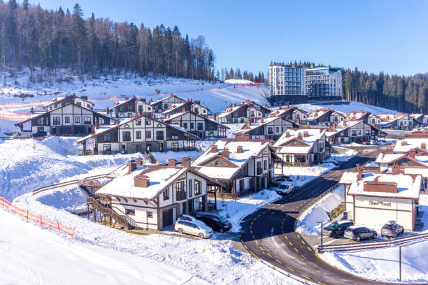 Aerial view of ski slopes and tourist cottages in the winter ski resort Bukovel, Ukraine Palianytsa village, Ivanofrankivsk region, Ukraine - January 14, 2021: Skiers and snowboarders resting at the Bukovel ski resort in the Carpathian mountains, Ukraine. Beautiful modern hotels and ski slopes. Active rest and holidays bukovel ski resort ukraine stock pictures, royalty-free photos & images