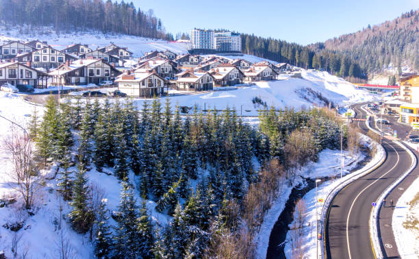 Aerial view of ski slopes and tourist cottages in the winter ski resort Bukovel, Ukraine Palianytsa village, Ivanofrankivsk region, Ukraine - January 14, 2021: Skiers and snowboarders resting at the Bukovel ski resort in the Carpathian mountains, Ukraine. Beautiful modern hotels and ski slopes. Active rest and holidays bukovel ski resort ukraine stock pictures, royalty-free photos & images