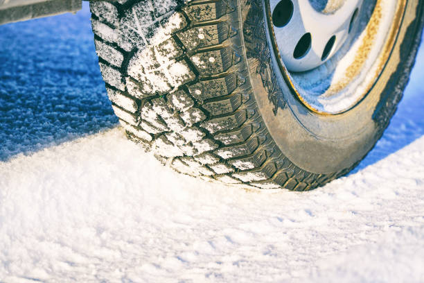 istock Studded winter car tires on snow-covered road 1341823720