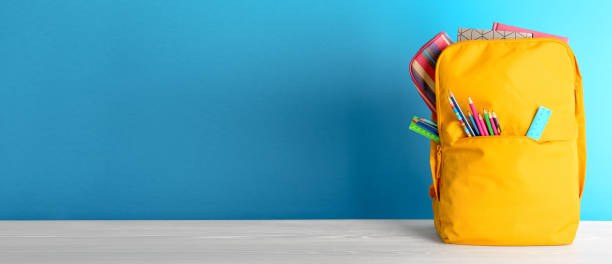 istock Backpack with different colorful stationery on table. Banner design 1341825192