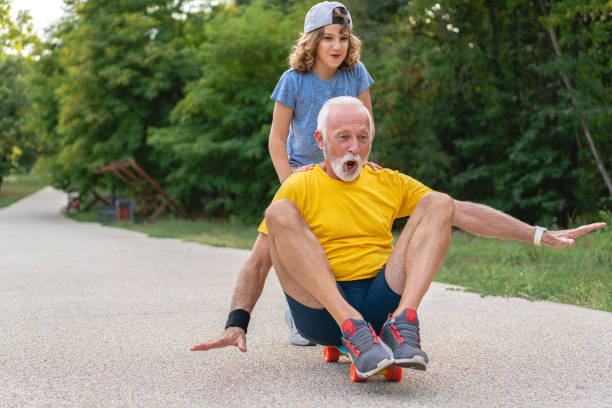 It’s grandpa first time on the skateboard stock photo