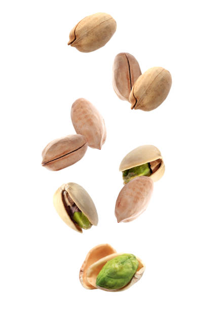 istock Tasty pistachio nuts falling on white background 1341826083