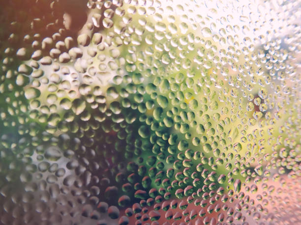 istock colorful water rain drop on glass window. 1341826619