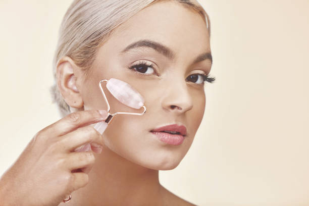 istock Studio shot of a young woman using a jade roller on her face 1341826796