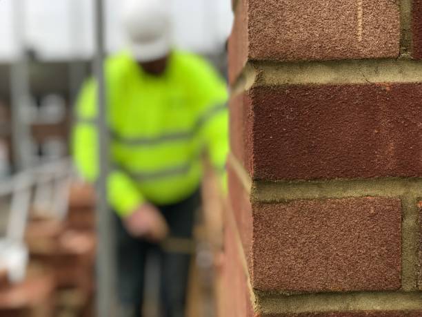 construtor em obras de pedreiro em uma extensão de casa ou nova casa de construção - brick construction construction site bricklayer - fotografias e filmes do acervo