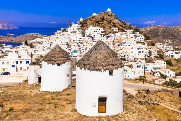 Photo of Greece travel. Cyclades. Traditional old windmills of Ios island. View of Chora village
