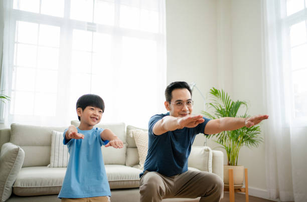 istock Father and son having fun exercising at home. 1341829384