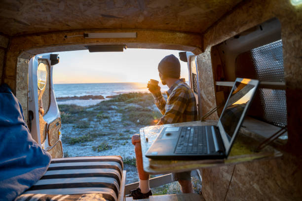 hombre se toma un descanso trabajando en una computadora portátil en la parte trasera de la autocaravana - hipster people surfing the net internet fotografías e imágenes de stock