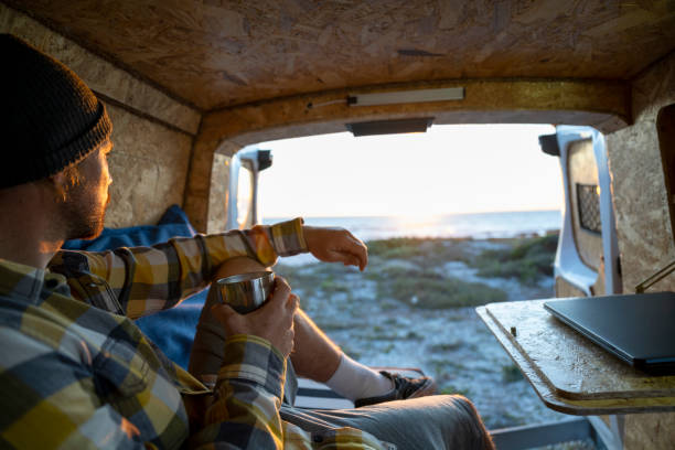istock Over shoulder view man relaxed in camper van looking at view 1341829459