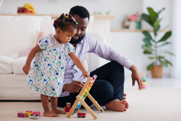 afroamerykańska rodzina, ojciec i córka bawiący się drewnianym liczydłem i zabawkami w domu - family american culture african culture black zdjęcia i obrazy z banku zdjęć