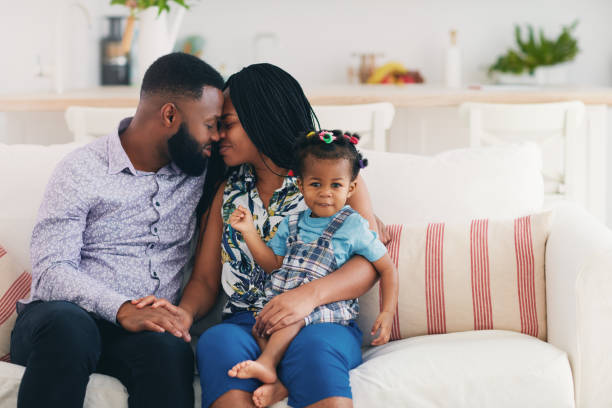 couple marié heureux �à la maison avec une petite fille, relations familiales - couple black american culture kissing photos et images de collection