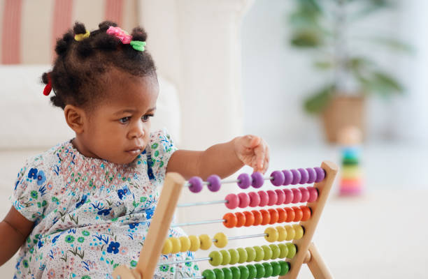 urocza afroamerykańska dziewczynka grająca kolorową zabawkę liczydła w domu - preschooler african ethnicity little girls child zdjęcia i obrazy z banku zdjęć