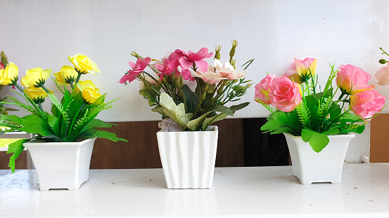 colorful plastic flowers in pots, usually these flowers are for display in the interior of the house