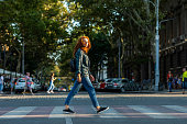 Woman crossing road to other side in big city