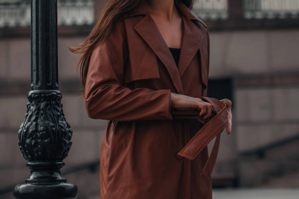 cropped elegante jovem mulher em elegante longo casaco de couro marrom. modelo de garota elegante posando. - belt leather fashion women - fotografias e filmes do acervo