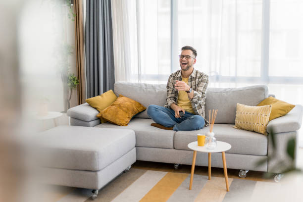istock Happy young man watching tv at home. 1341836772