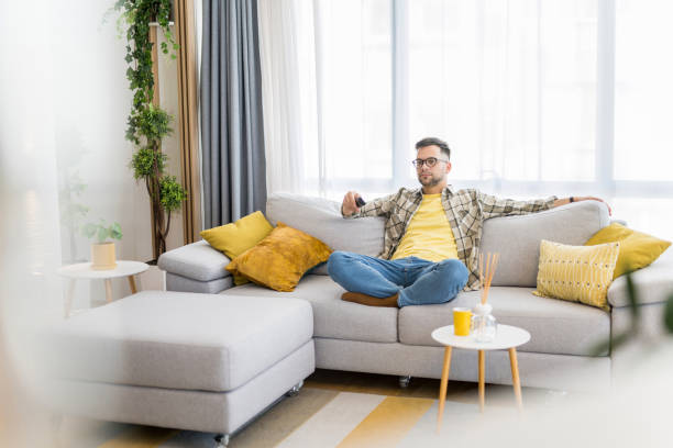 istock Happy young man watching tv at home. 1341837350