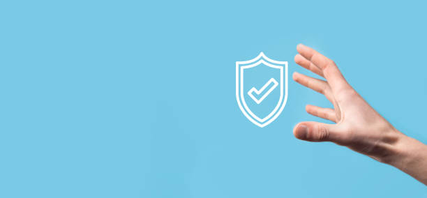 istock Male hand holding protect shield with a check mark icon on blue background. Protection network security computer and safe your data concept . 1341838408