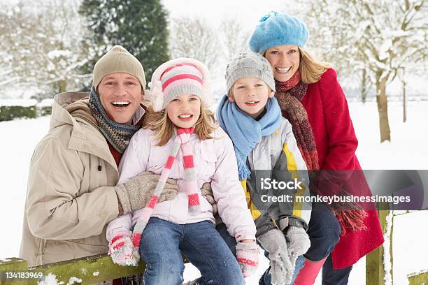 Family Sitting In Verschneite Landschaft Stockfoto und mehr Bilder von Familie - Familie, Schnee, 6-7 Jahre