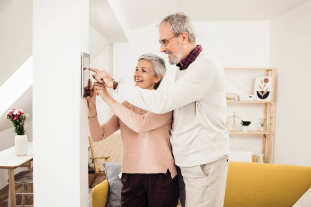 istock Senior couple adjusting a smart system in their home 1341844857