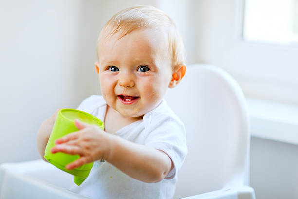 활기참 아기 여자아이 의자에 및 쥠 컵 - baby cup 뉴스 사진 이미지