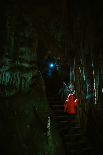 Tourist woman and her daughter walking through the underground cave in the Dinaric Alps.