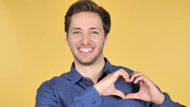istock Handmade Heart by Young Man Isolated on Yellow Background 1341846154