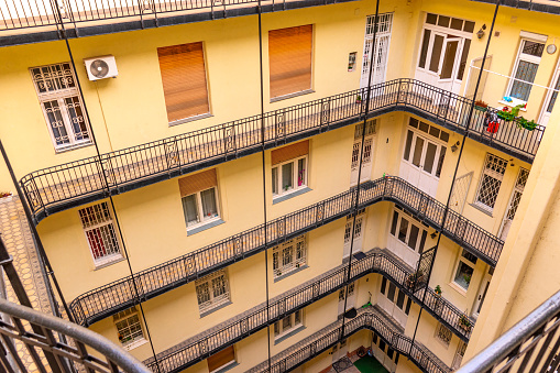 inner courtyard of an apartment building. european archtecture. budapest, hungary. balconies to the courtyard of a multi-storey building. view from top floor. Housing conditions in the old town quarter
