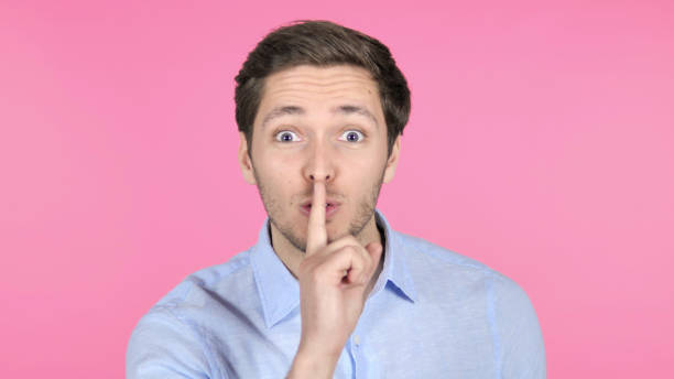 istock Finger on Lips by Young Man Isolated on Pink Background 1341846337