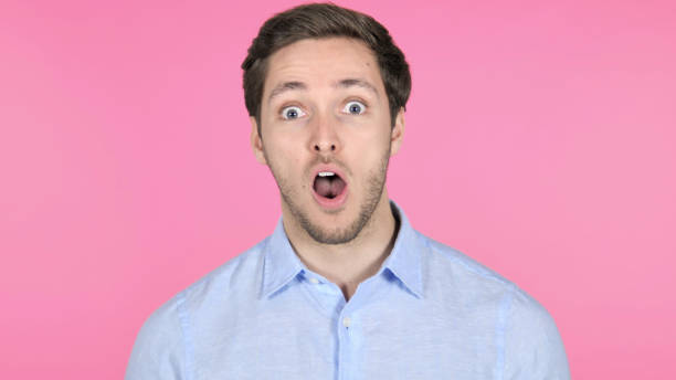 istock Surprised Young Man Wondering on Pink Background 1341848491