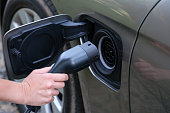 Man inserting electric cable into car charger closeup