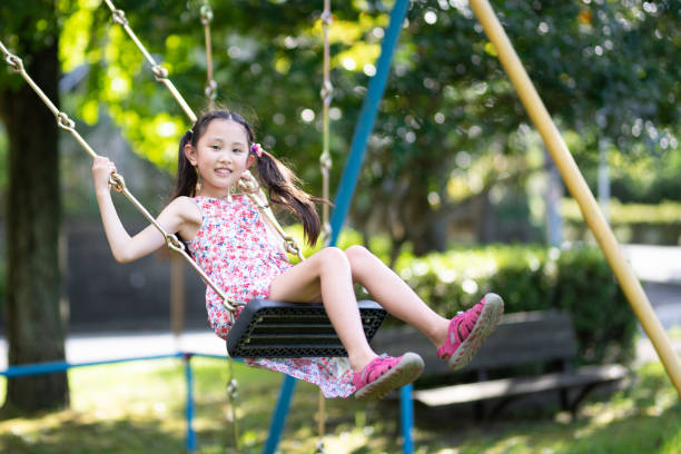 istock Girl playing on a swing 1341848931
