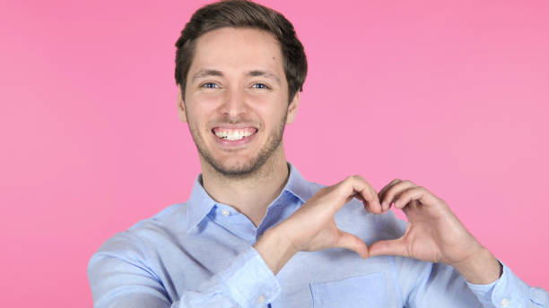 istock Handmade Heart by Young Man Isolated on Pink Background 1341849940