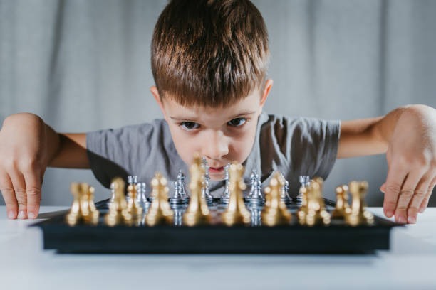 istock Child learns to play chess in his room at home 1341852689